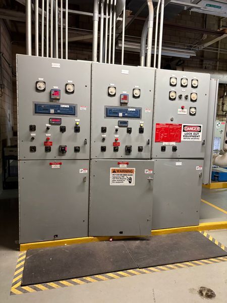 Gray paralleling switchgear with gauges and switches